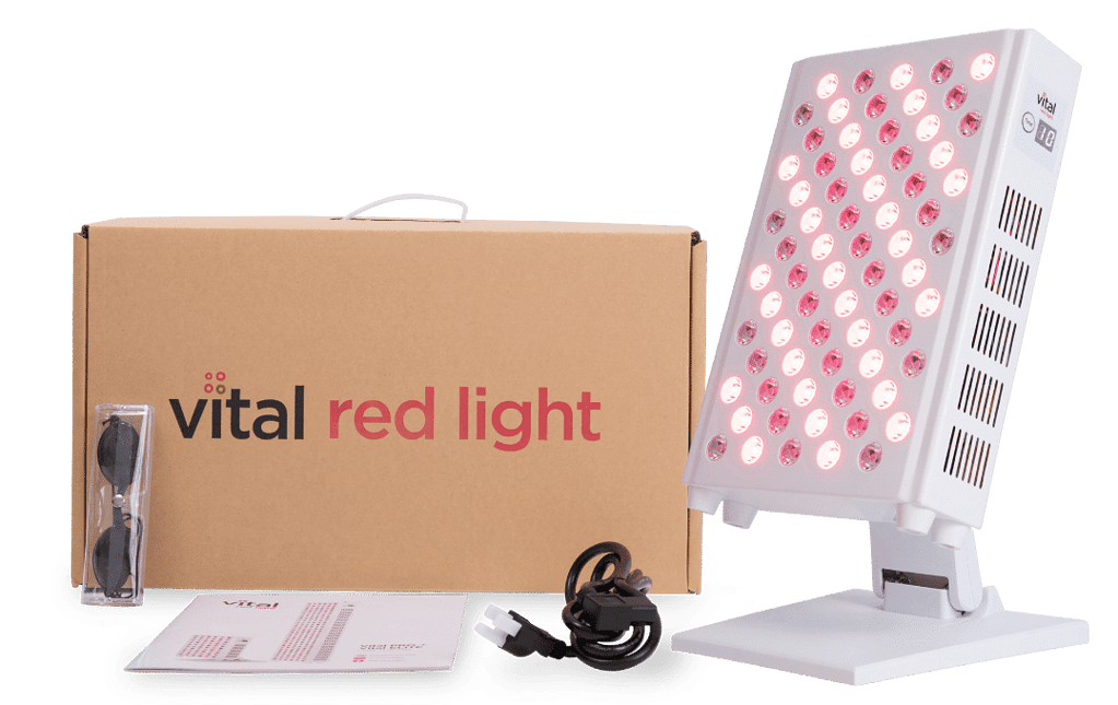 The Vital Pro red light therapy device features an LED panel on a stand, complete with goggles, power cord, instruction manual, and elegantly branded packaging box.