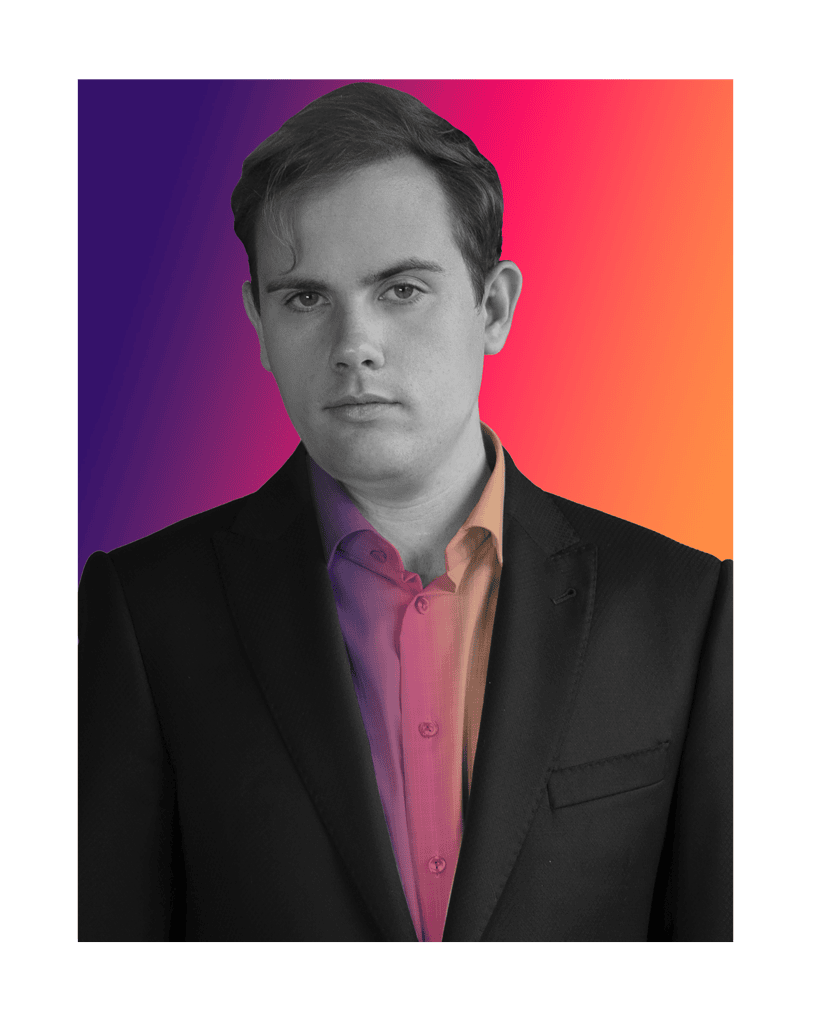 A person in a dark suit with a neutral expression stands before a vibrant gradient background in shades of purple, orange, and pink.